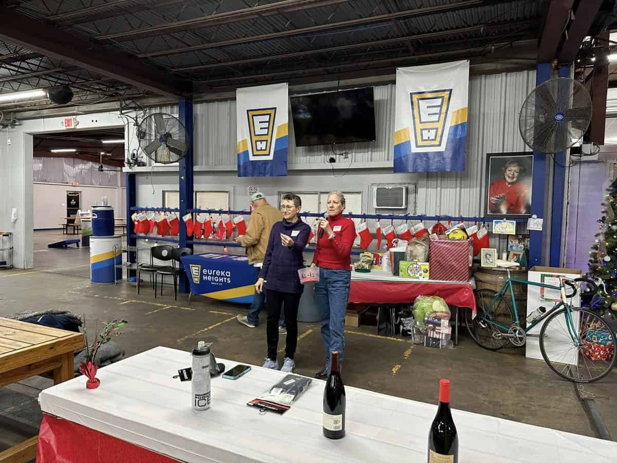 Bright indoor event at Eureka Heights brewery with Northwest Cycling Club banners, festive stockings, and cycling memorabilia.
