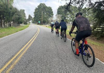 Cycling group riding on scenic rural road, Northwest Cycling Club outdoor activity.