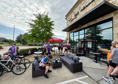 Cyclists resting at Northwest Cycling Club café after a group ride, enjoying coffee and conversations.