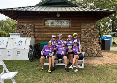 Group of cyclists wearing NWCC jerseys taking a break at Northwest Cycling Club event or ride.