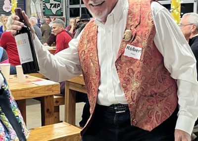 Cycling In Houston - NWCC Recent Activities Gallery 659 Vintage cycling enthusiast celebrating at Northwest Cycling Club event, holding a bottle of wine.
