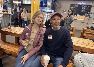 Cycling In Houston - NWCC Recent Activities Gallery 601 Happy cyclists enjoying social time at Northwest Cycling Club event, with friends and beverages at a lively indoor venue.