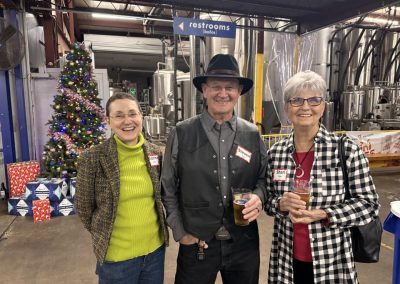 Cycling In Houston - NWCC Recent Activities Gallery 635 Festive cycling club members enjoying drinks at Northwest Cycling Club holiday event indoors with Christmas decorations.