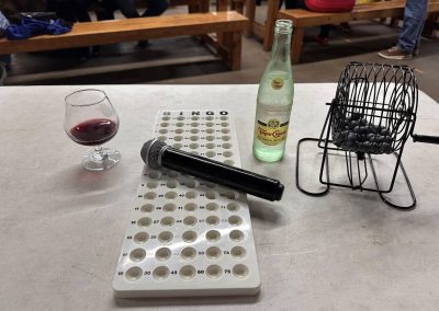 Cycling In Houston - NWCC Recent Activities Gallery 594 Microphone, bingo game card, wine glass, water bottle, and bingo cage on a table at Northwest Cycling Club event.