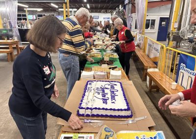 Cycling In Houston - NWCC Recent Activities Gallery 609 People celebrating and cutting a large holiday cake at Northwest Cycling Club event.