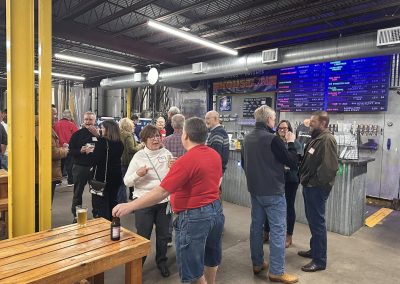 Cycling In Houston - NWCC Recent Activities Gallery 628 Vibrant group of cyclists enjoying craft beers at Northwest Cycling Club event in a modern indoor venue.