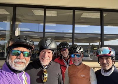 Cycling In Houston - NWCC Recent Activities Gallery 587 Group of male cyclists smiling in front of a building, wearing helmets and cycling gear.