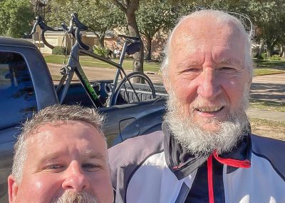 Cycling In Houston - NWCC Recent Activities Gallery 572 Older men cycling enthusiasts, smiling outdoors after a ride with bikes in the background, promoting U.S. cycling clubs and community biking events.
