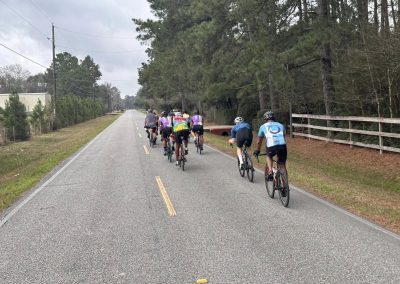 Cycling In Houston - NWCC Recent Activities Gallery 562 Cycling group riding on a scenic rural road through wooded area.