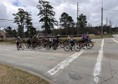 Cycling In Houston - NWCC Recent Activities Gallery 557 Group of cyclists crossing an intersection during a Northwest Cycling Club ride, promoting community outdoor fitness.