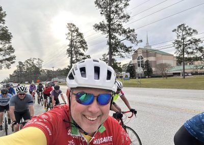 Cycling In Houston - NWCC Recent Activities Gallery 548 Cycling group riding with Northwest Cycling Club, smiling cyclist wearing red jersey and sunglasses.