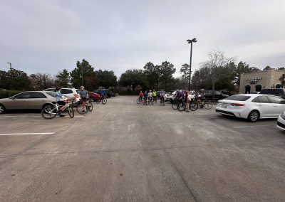 Cycling In Houston - NWCC Recent Activities Gallery 550 Group of cyclists gathering in a parking lot for a Northwest Cycling Club ride, with cars and Starbucks in the background.