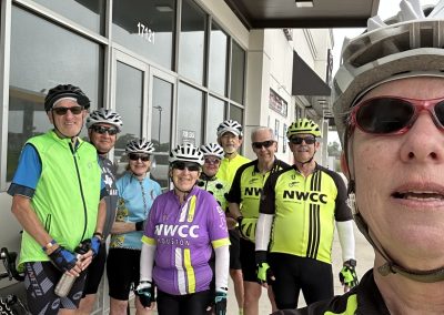 Cycling In Houston - NWCC Recent Activities Gallery 516 Active group of cyclists wearing NWCC cycling jerseys outside bike shop for Northwest Cycling Club event.
