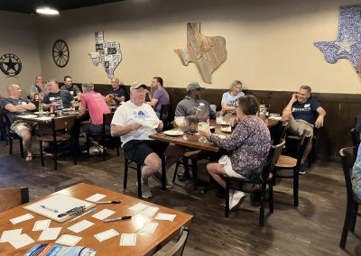 Cycling In Houston - NWCC Recent Activities Gallery 528 Group of cyclists gathering at Northwest Cycling Club event, enjoying a meal indoors.