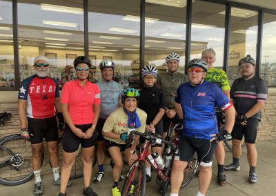 Cycling In Houston - NWCC Recent Activities Gallery 515 Pleasant group of cyclists posing outside a bike shop for Northwest Cycling Club event, showcasing community and cycling passion.