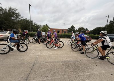 Cycling In Houston - NWCC Recent Activities Gallery 506 Group of cyclists with helmets in a parking lot for Northwest Cycling Club event, promoting community biking.