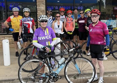 Cycling In Houston - NWCC Recent Activities Gallery 504 A group of cyclists posing in front of a storefront, showcasing membership in Northwest Cycling Club Houston.