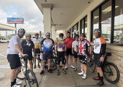 Cycling In Houston - NWCC Recent Activities Gallery 503 Group of cyclists with helmets and bikes outside a cafe, promoting Northwest Cycling Club activities.