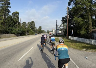 Cycling In Houston - NWCC Recent Activities Gallery 470 Group of cyclists riding on a scenic road, promoting outdoor cycling and fitness.