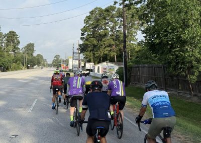 Cycling In Houston - NWCC Recent Activities Gallery 469 Cyclists riding together on a scenic road for Northwest Cycling Club events, promoting community and cycling fitness.