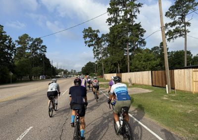 Cycling In Houston - NWCC Recent Activities Gallery 471 Cycling group riding on a scenic road with tall trees, part of Northwest Cycling Club outings.
