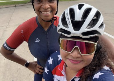Cycling In Houston - NWCC Recent Activities Gallery 452 Smiling female cyclist with helmet and sunglasses, celebrating outdoor cycling with Northwest Cycling Club.
