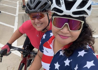 Cycling In Houston - NWCC Recent Activities Gallery 434 High-angle photo of two women wearing cycling gear, helmets, and sunglasses at Northwest Cycling Club event.
