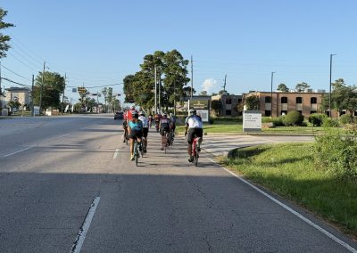 Cycling In Houston - NWCC Recent Activities Gallery 406 Cycling group riding on city street in Northwest Cycling Club community.