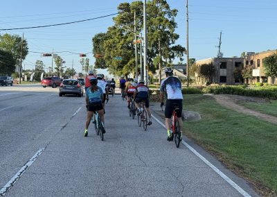 Cycling In Houston - NWCC Recent Activities Gallery 405 Group of cyclists riding together on a sunny urban bike lane route for outdoor cycling and fitness.