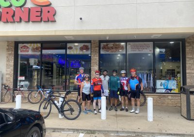 Cycling In Houston - NWCC Recent Activities Gallery 431 Group of cyclists in cycling gear outside Northwest Cycling Club bakery, ready for a ride.