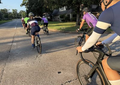 Cycling In Houston - NWCC Recent Activities Gallery 382 Cycling group riding together in a neighborhood, promoting community and fitness.
