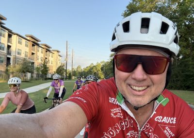 Cycling In Houston - NWCC Recent Activities Gallery 386 Smiling cyclist taking a selfie with group riding on a scenic bike path in Northwest Portland.