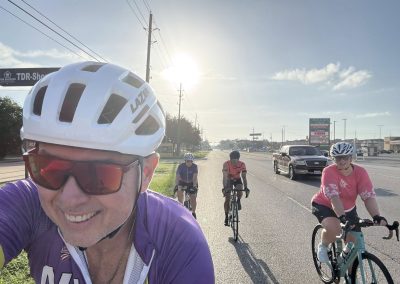 Cycling In Houston - NWCC Recent Activities Gallery 344 Cycling group riding on city street with Northwest Cycling Club, outdoor biking, community cycling event, sunny day.
