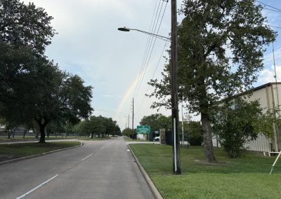 Cycling In Houston - NWCC Recent Activities Gallery 332 Empty street in a suburban area with trees and utility poles, supported by Northwest Cycling Club community biking events.
