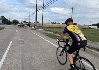 Cycling In Houston - NWCC Recent Activities Gallery 285 Cycling group riding through a city street, promoting fitness and community with Northwest Cycling Club.