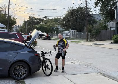 Cycling In Houston - NWCC Recent Activities Gallery 307 Bicycle rider with fuel bottles by car, part of Northwest Cycling Club outdoor cycling event.