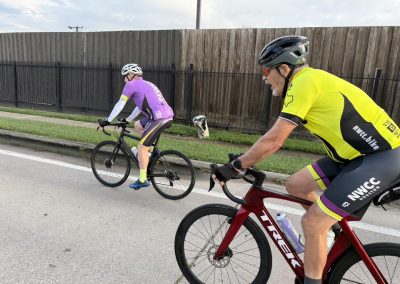 Cycling In Houston - NWCC Recent Activities Gallery 276 Vibrant cyclists participating in Northwest Cycling Club's group ride on scenic urban road.