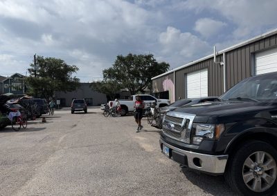 Cycling In Houston - NWCC Recent Activities Gallery 258 Bicycle riders preparing at Northwest Cycling Club parking lot with bikes and vehicles in the background.