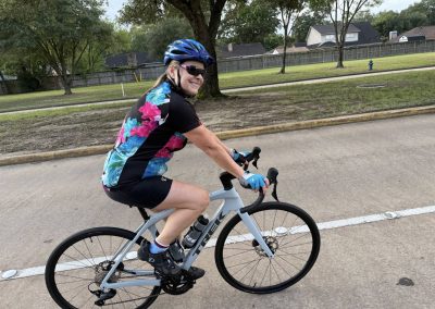 Cycling In Houston - NWCC Recent Activities Gallery 330 Bright woman cycling on a scenic trail as part of Northwest Cycling Club, promoting active outdoor lifestyles.