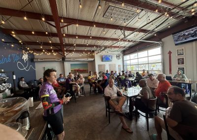Cycling In Houston - NWCC Recent Activities Gallery 251 Cycling club meeting at NWCC bike shop with community of passionate cyclists in a lively indoor space.