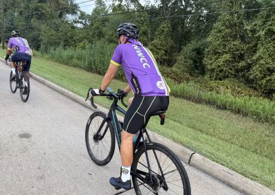 Cycling In Houston - NWCC Recent Activities Gallery 264 Cycling members riding on scenic road with lush greenery - Northwest Cycling Club event.