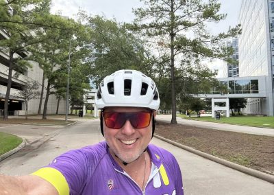 Cycling In Houston - NWCC Recent Activities Gallery 331 Cyclist smiling in helmet and purple jersey during Northwest Cycling Club ride.