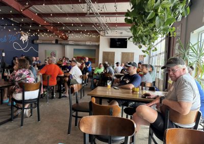 Cycling In Houston - NWCC Recent Activities Gallery 248 Large group of people attending a Northwest Cycling Club meet-up or event inside a vibrant, well-lit restaurant or café.