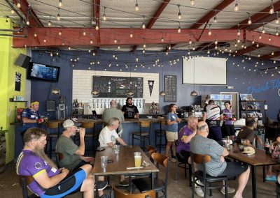 Cycling In Houston - NWCC Recent Activities Gallery 244 Rustic indoor bar at Northwest Cycling Club with cyclists enjoying drinks and socializing.