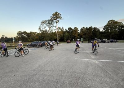 Cycling In Houston - NWCC Recent Activities Gallery 237 Cycling group members in NWCC jerseys preparing in a parking lot for a bike ride.
