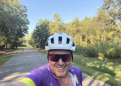Cycling In Houston - NWCC Recent Activities Gallery 217 Vibrant cyclist wearing a purple jersey and helmet enjoying scenic biking with Northwest Cycling Club.