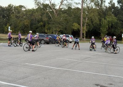 Cycling In Houston - NWCC Recent Activities Gallery 231 Cycling group practice at Northwest Cycling Club parking lot with scenic trees in background.