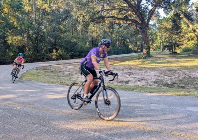 Cycling In Houston - NWCC Recent Activities Gallery 199 Scenic cycling route with two cyclists on outdoor bike ride in lush park environment.