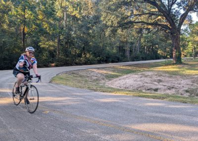 Cycling In Houston - NWCC Recent Activities Gallery 210 Cyclist riding on scenic park road with trees, part of Northwest Cycling Club community.