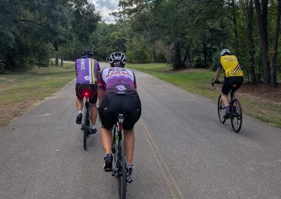 Cycling In Houston - NWCC Recent Activities Gallery 195 Biking group riding on scenic park trail with lush trees, part of Northwest Cycling Club events.